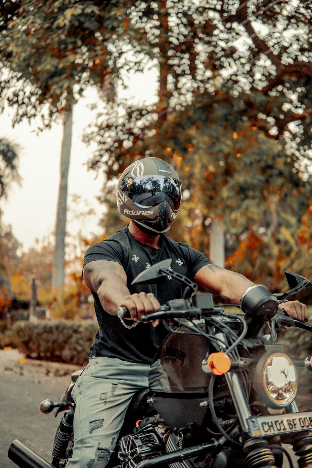 a man riding on the back of a motorcycle down a street