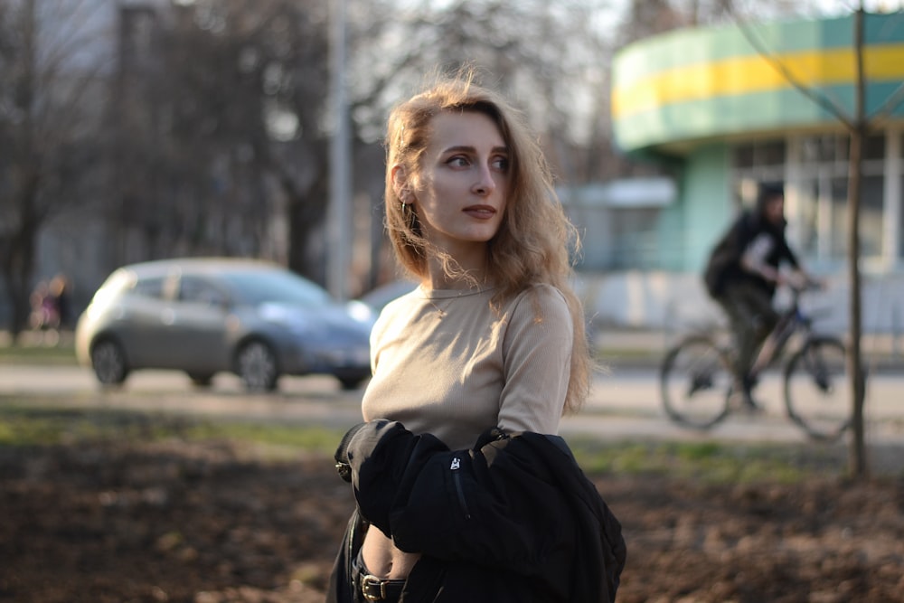 woman in white long sleeve shirt and black pants sitting on ground during daytime