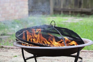 A sleek, weather-resistant fire pit cover protecting a fire pit on a rainy day.
