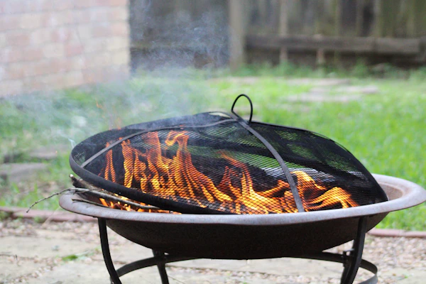 A durable fire pit cover snugly fitted over a round fire pit, protecting it from rain and leaves.