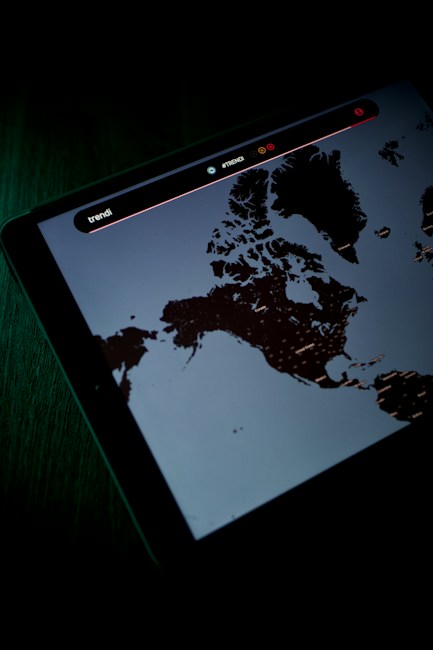 A digital screen displaying a map, possibly of Northern regions, with text and icons above the map. The screen is emitting a dim light, creating a contrast against the dark surroundings.