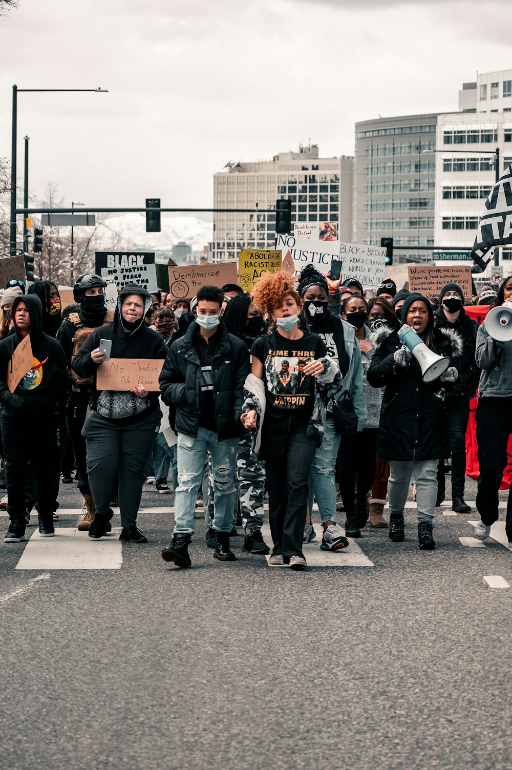 group of people standing on gray asphalt road during daytime