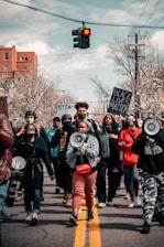 group of people in black and red jacket holding black and white camera during daytime