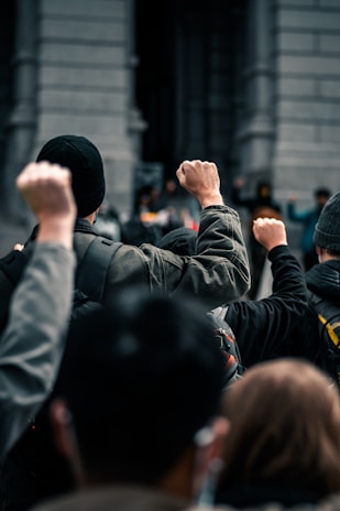 Close-up of hands shaking firmly in front of a government building symbolizing solidarity.