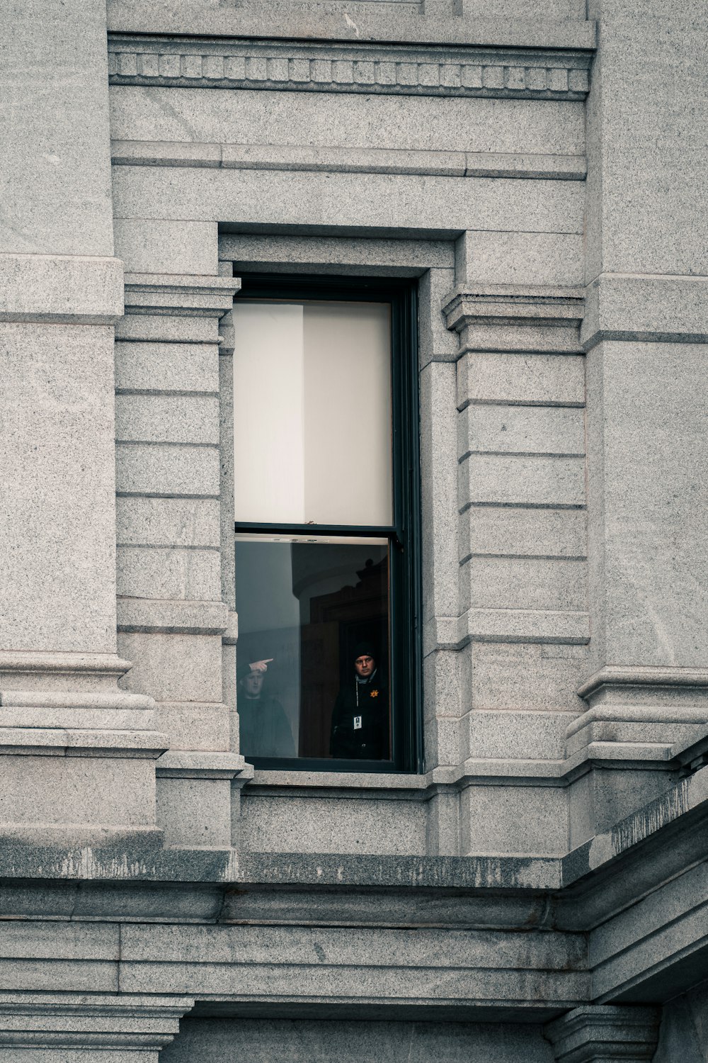 Fenêtre en verre à cadre noir sur un bâtiment en béton gris
