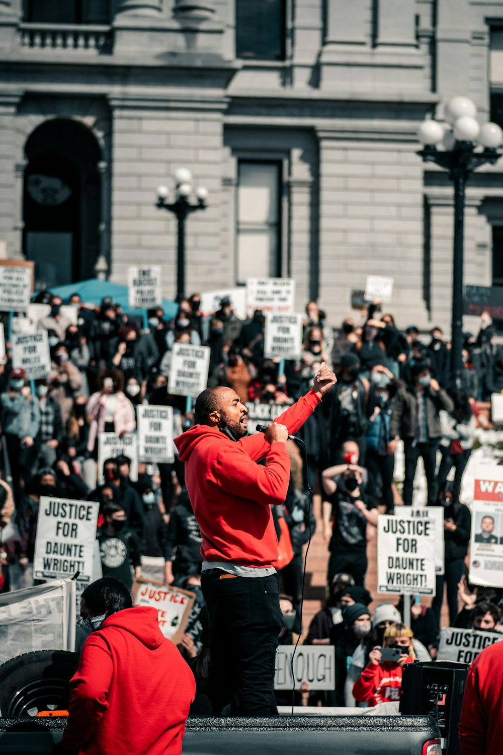 man in red hoodie raising his hands