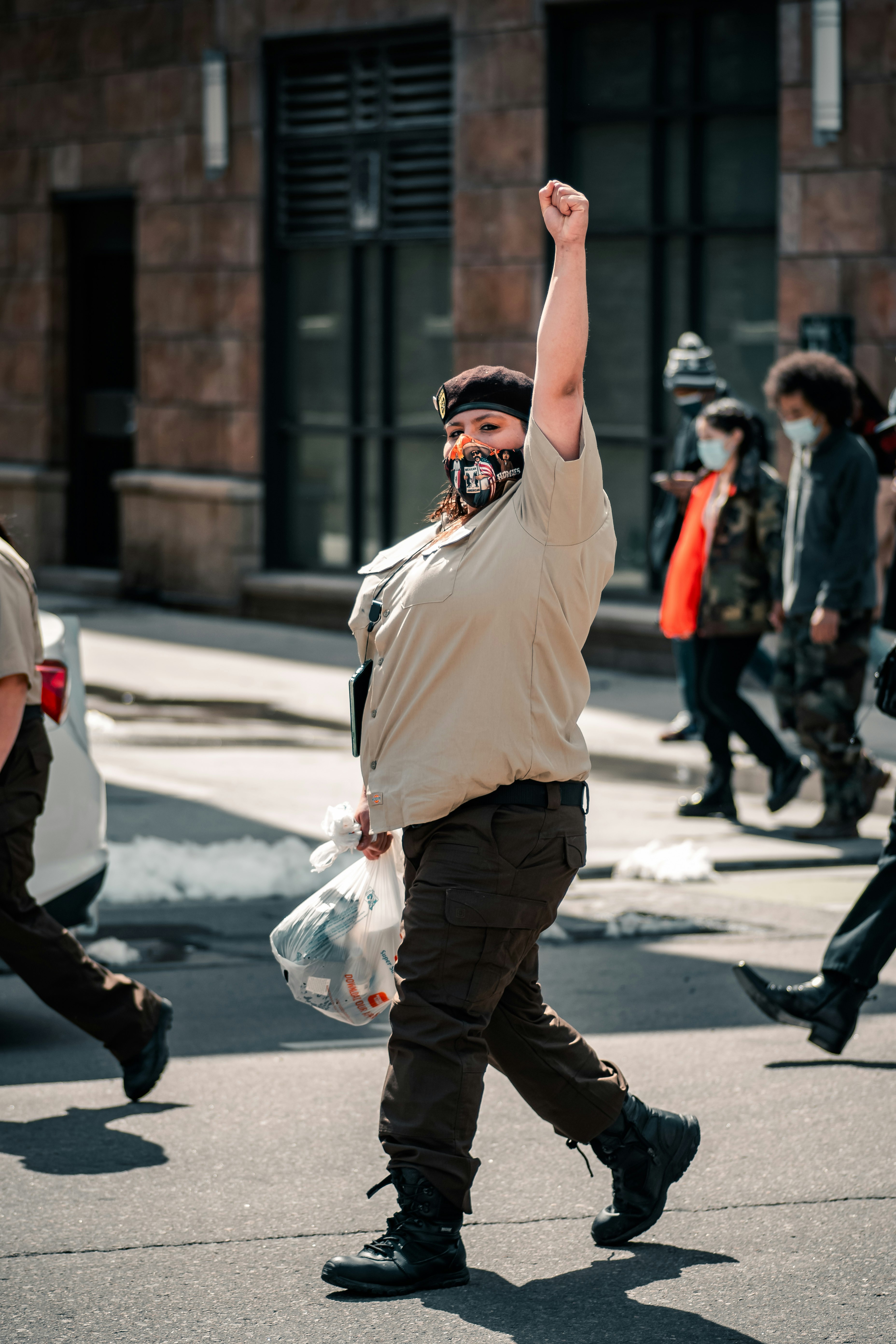 man in white crew neck t-shirt and brown pants holding clear plastic bag