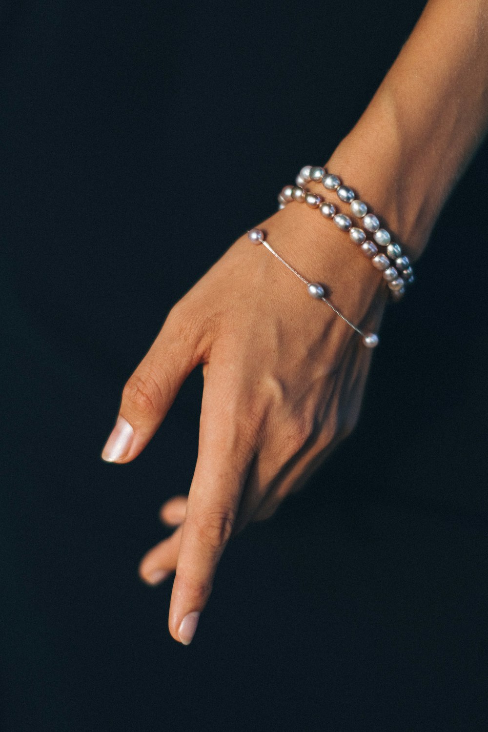 person wearing silver bracelet and gold ring