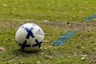 white and blue soccer ball on green grass field during daytime