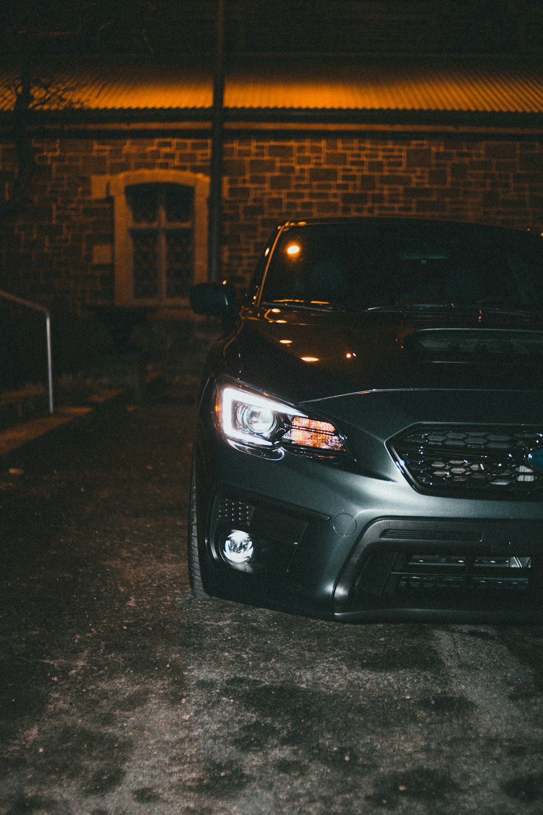 black car parked on sidewalk during night time