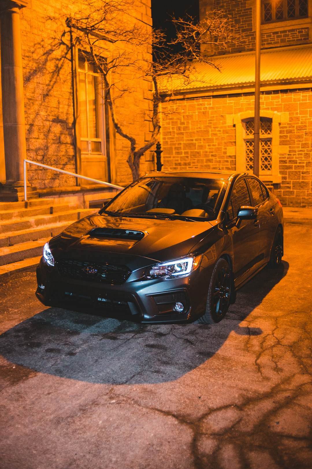 black honda sedan parked beside brown brick wall