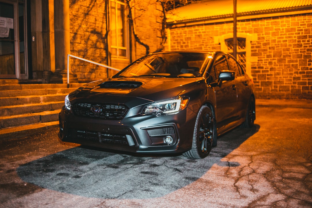 black honda car parked beside brown building