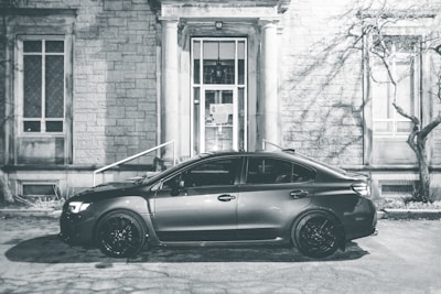 A rental car from the company parked in front of a business building