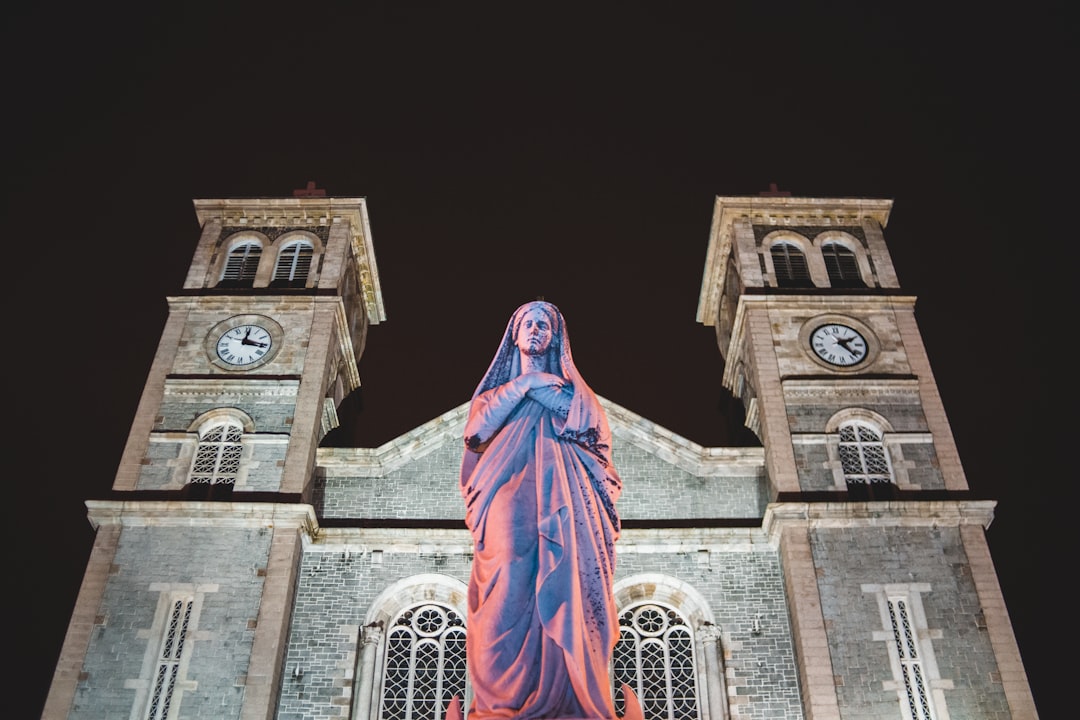 jesus christ statue in front of brown concrete building