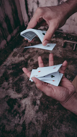 A close-up of a magician's hands performing a card trick.