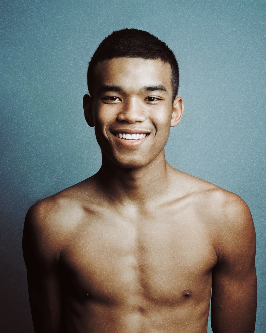 topless man smiling in front of the camera