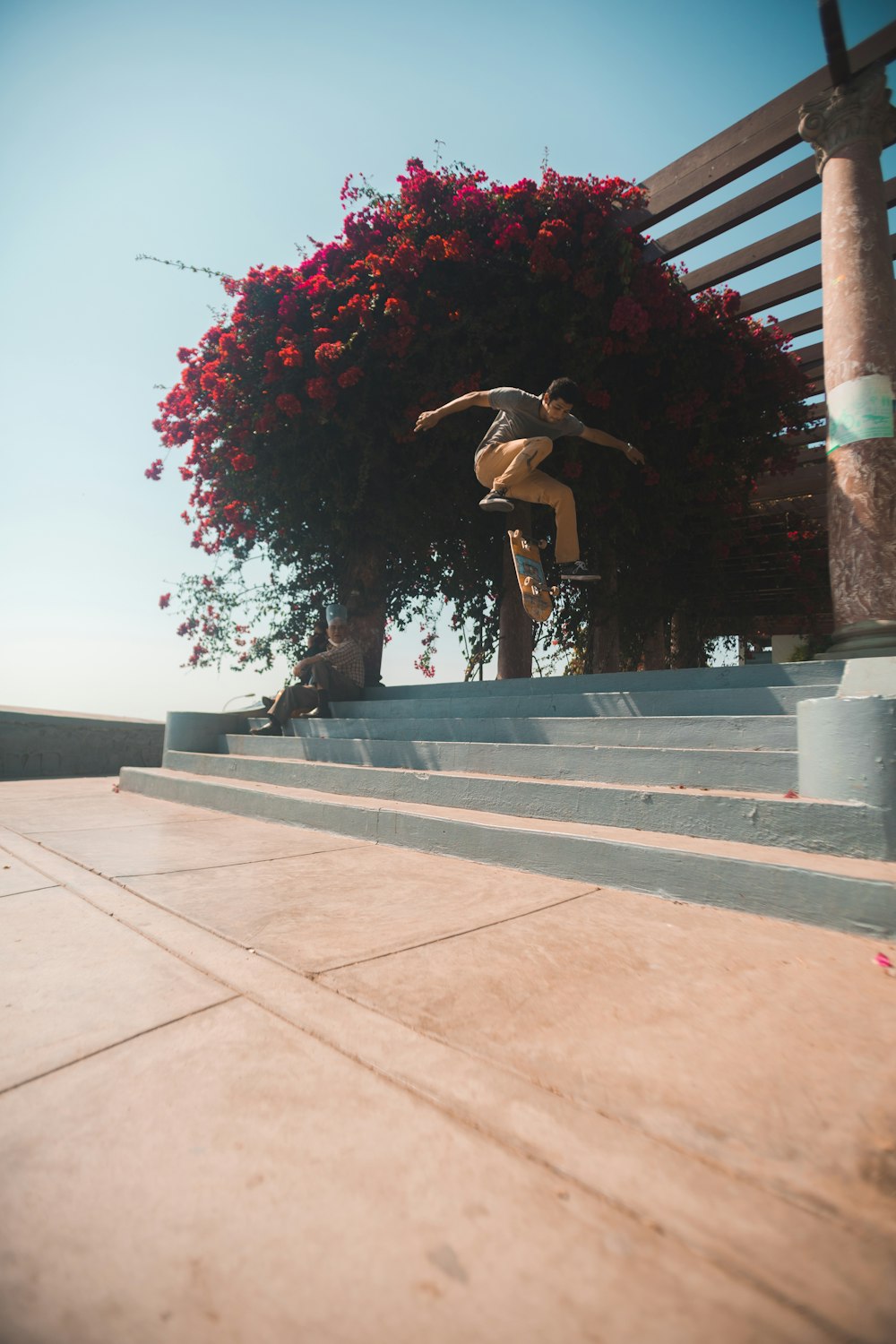 woman in black tank top and black pants jumping on brown concrete floor during daytime