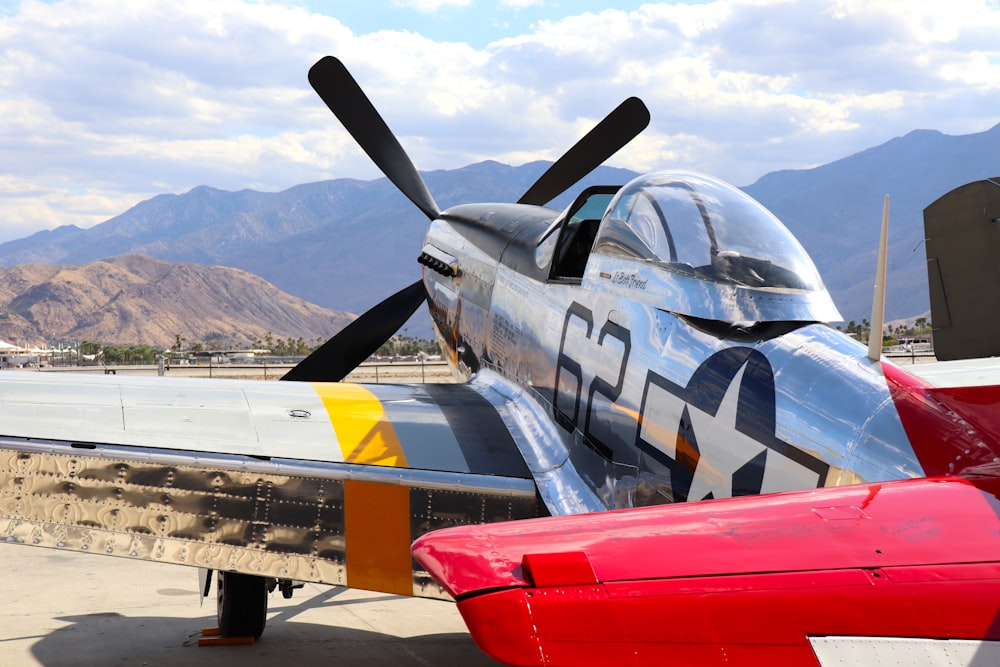 red and gray fighter plane on the road during daytime