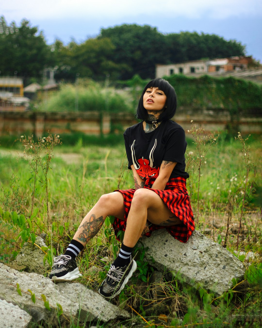 woman in black and red dress sitting on rock near river during daytime