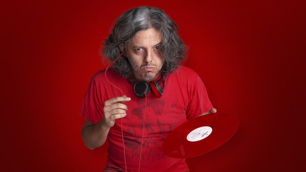 man in red crew neck t-shirt wearing black headphones