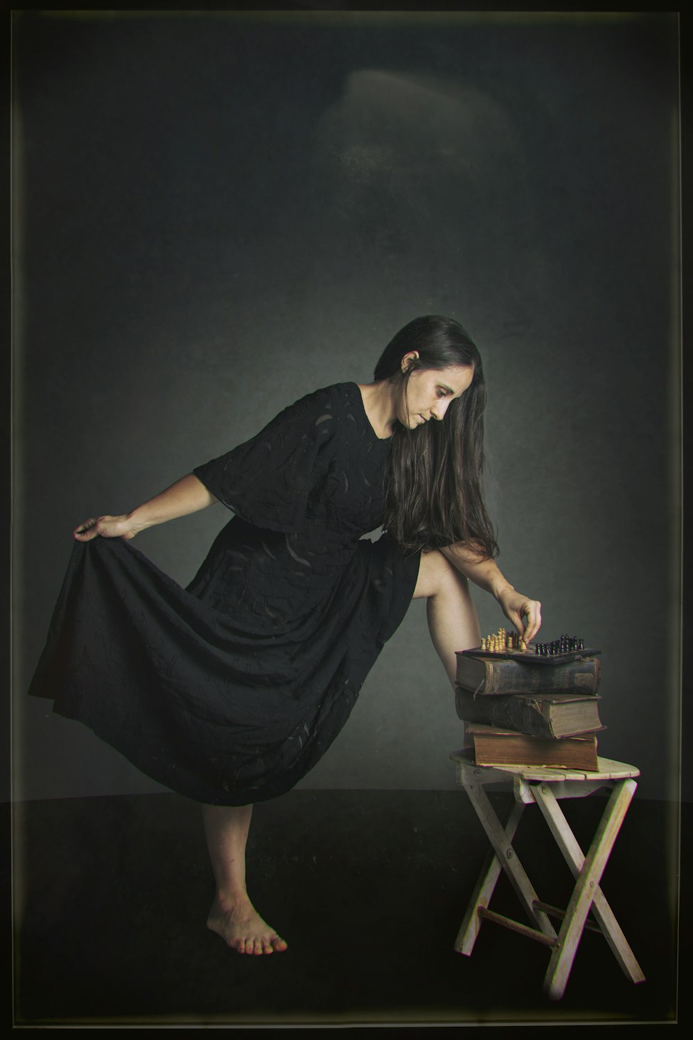 Femme en robe noire assise sur un siège en bois marron