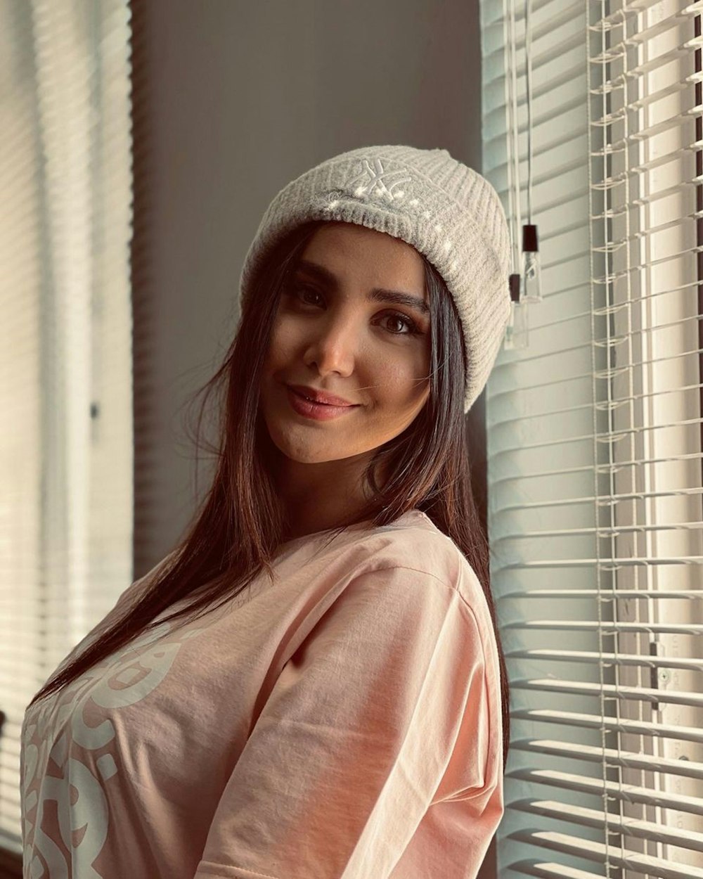 woman in pink long sleeve shirt wearing white hat