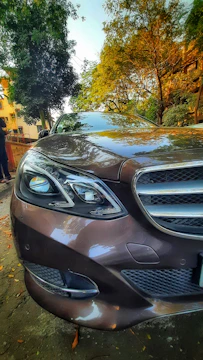 Side view of a shiny sedan parked beside a scenic road