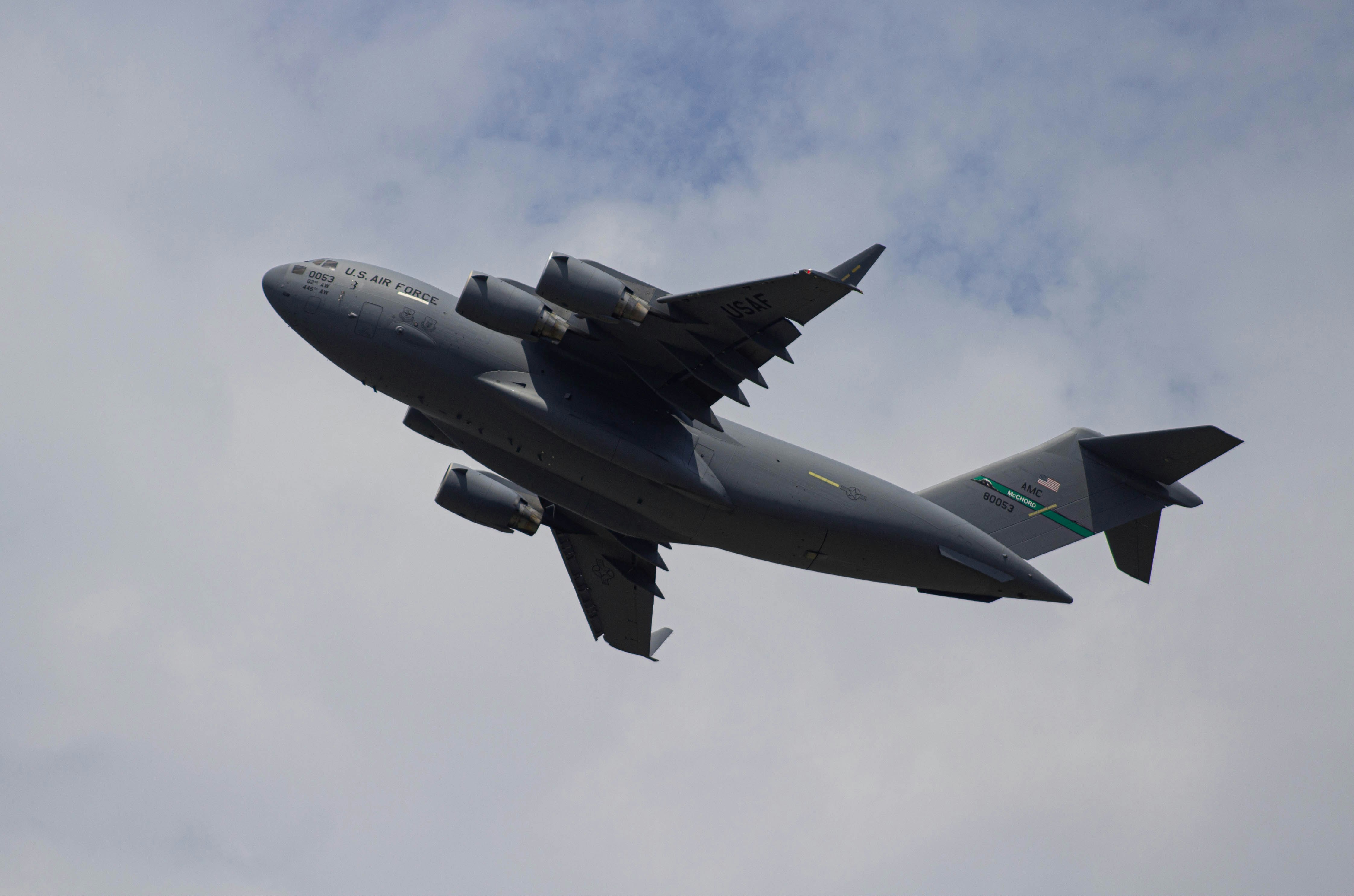 gray jet plane under white clouds during daytime