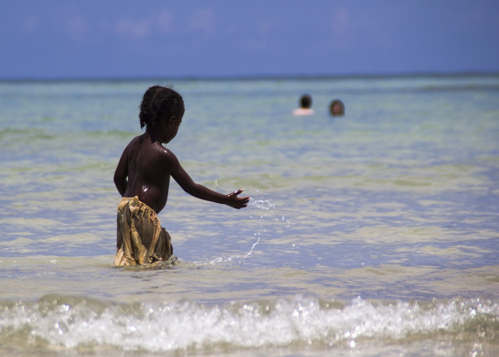 woman in yellow dress sitting on beach during daytime