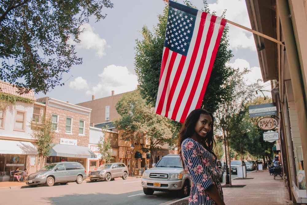 woman holding us a flag standing on road during daytime