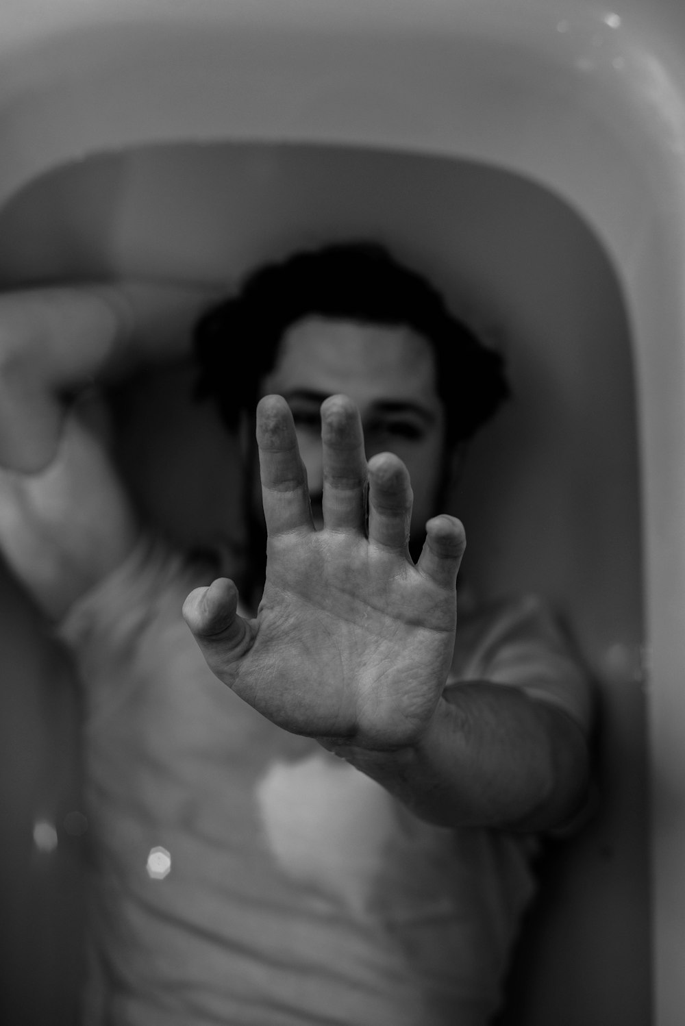 grayscale photo of woman covering her face with her hand