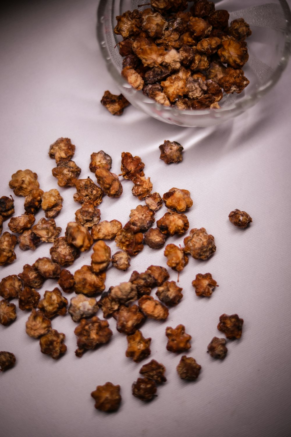 brown peanuts on clear glass bowl