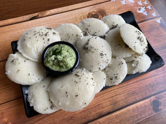A rustic clay plate filled with steaming hot litti chokha, garnished with fresh coriander and a side of tangy chutney.