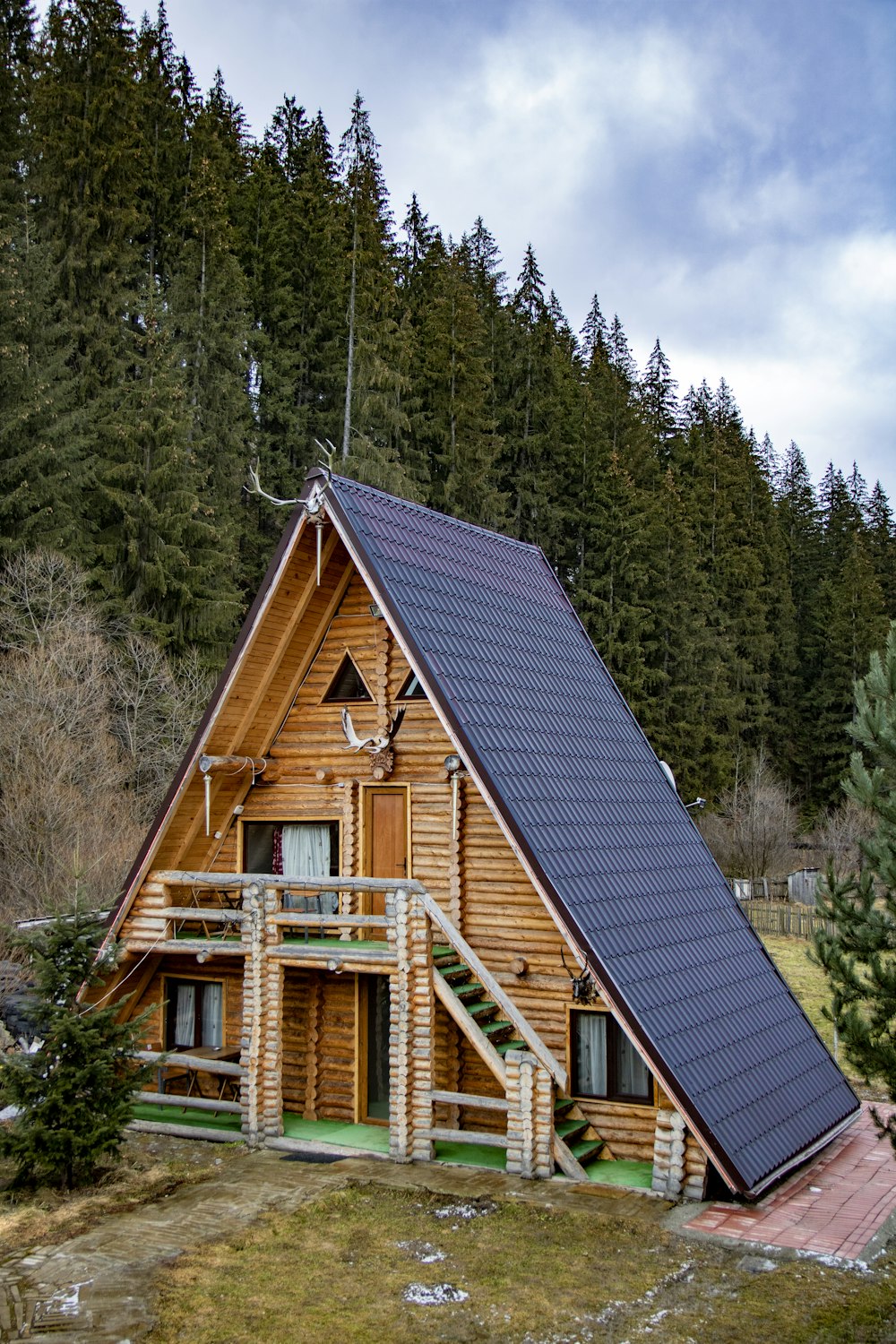 brown wooden house surrounded by green trees during daytime