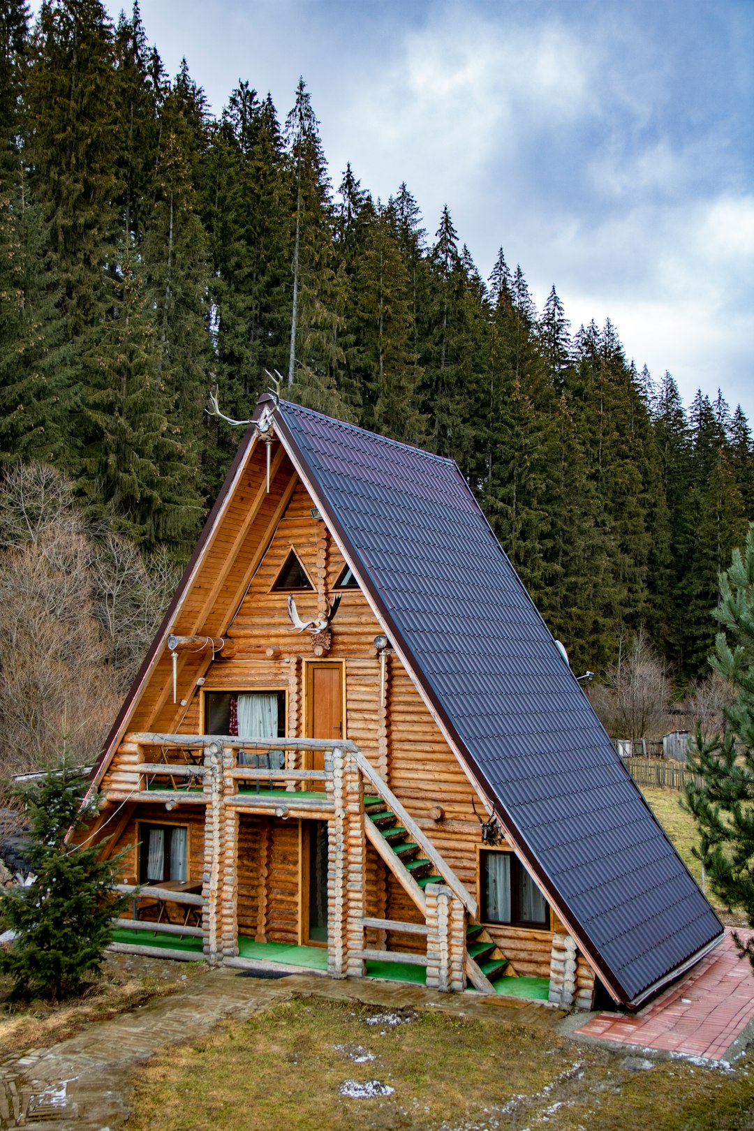 brown wooden house surrounded by green trees during daytime