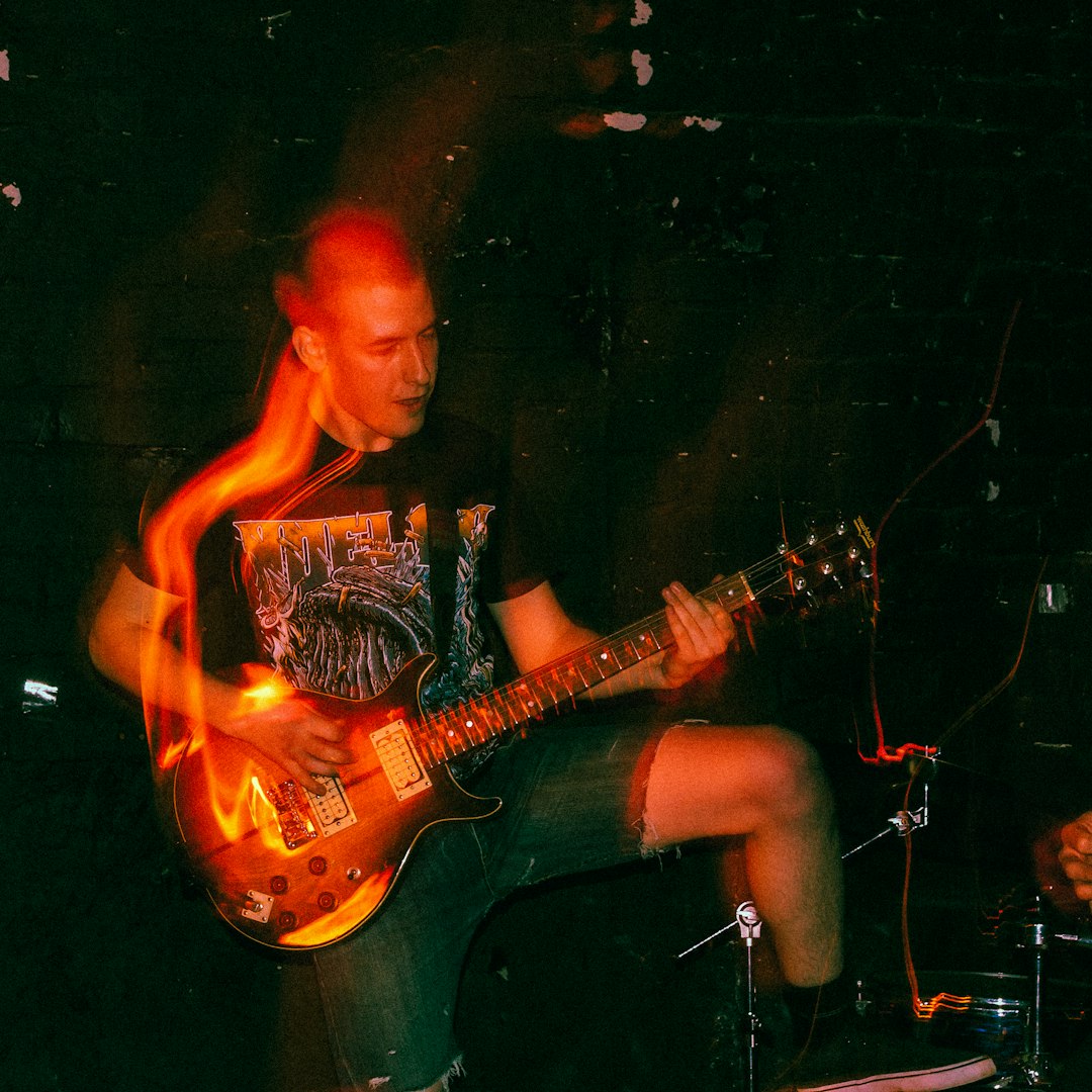 man in black shirt playing electric guitar