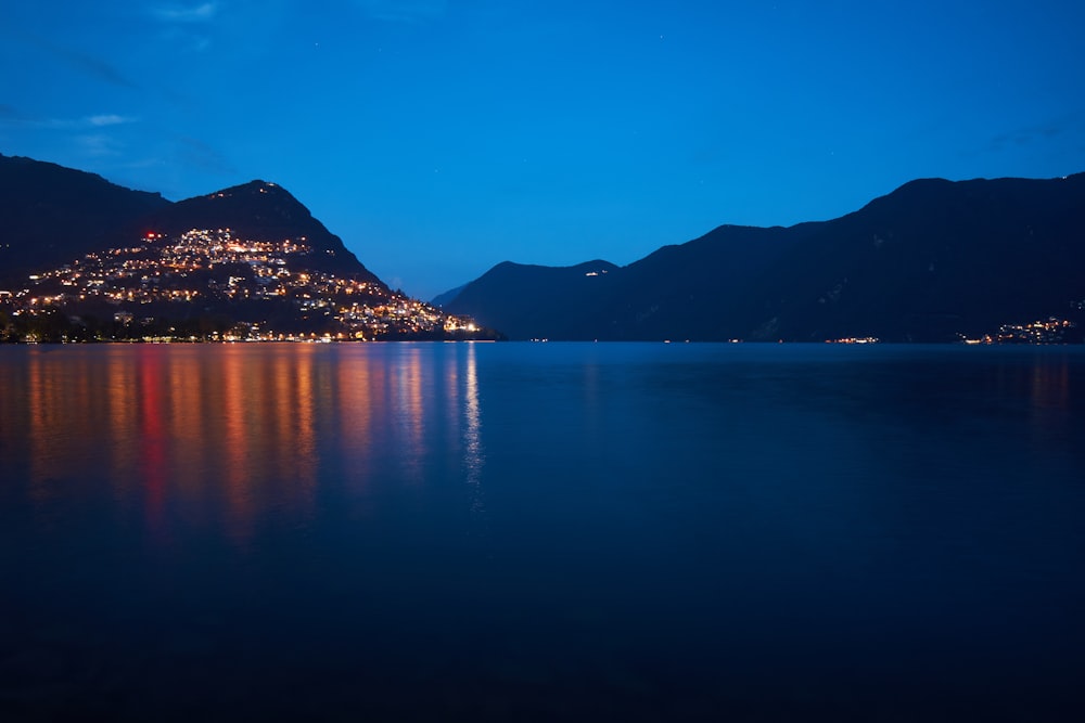 blue body of water near mountain during daytime