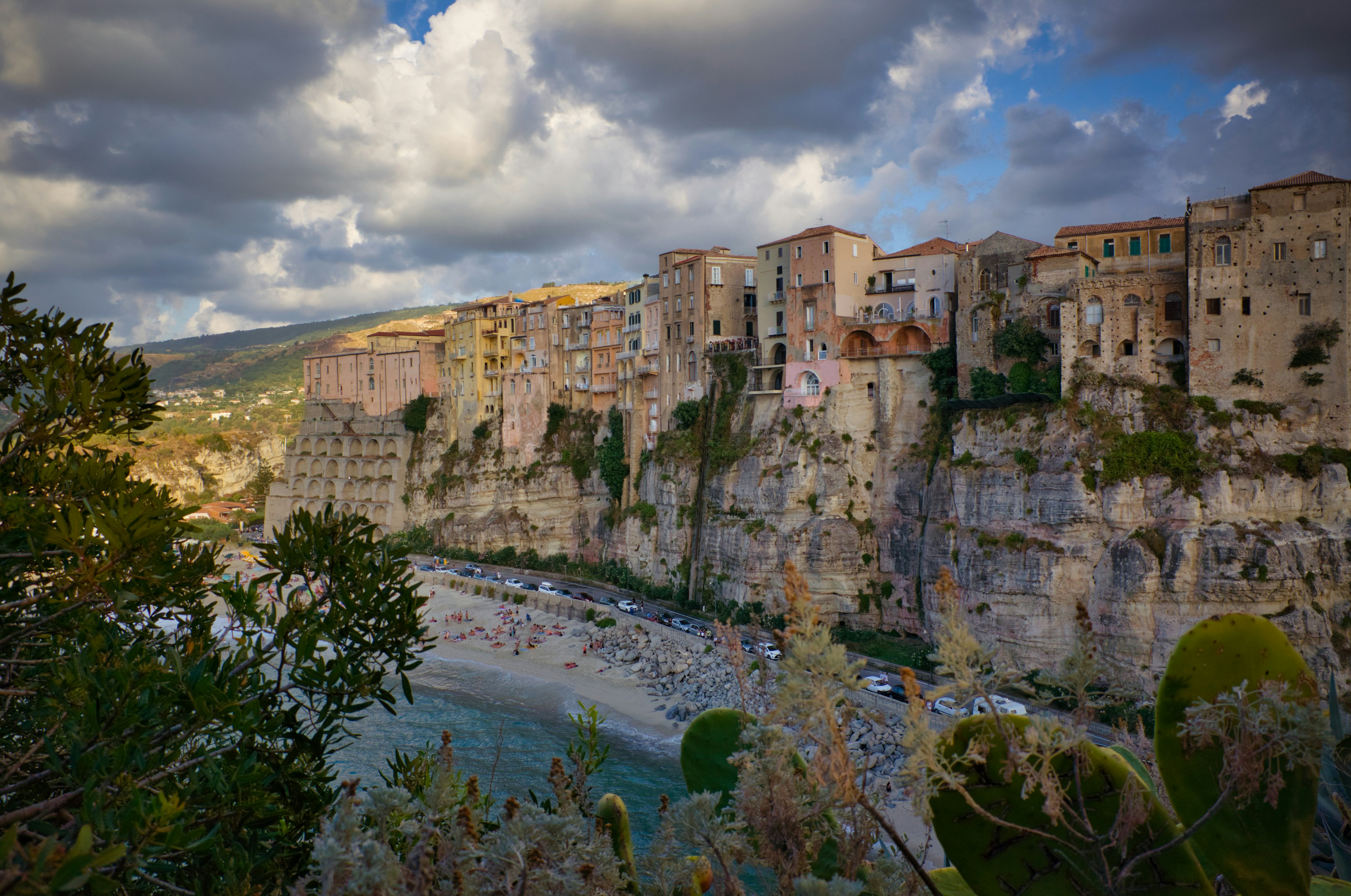 Colorful buildings cascading down Amalfi coast cliffs toward bright blue Mediterranean sea, vivid sunlit scene