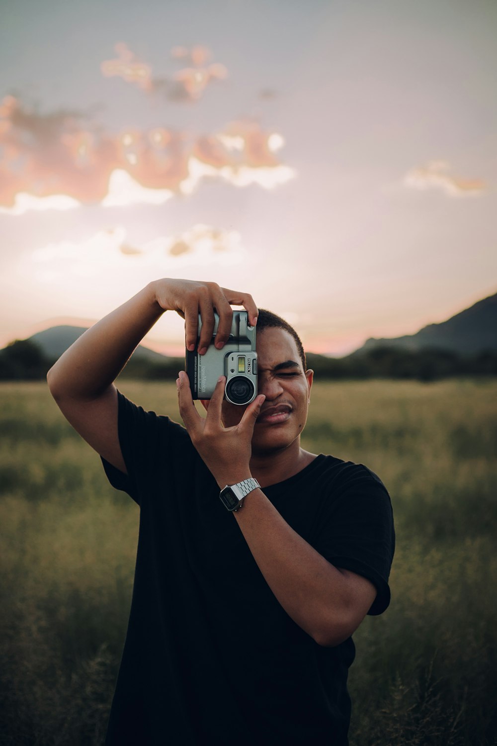 man in black crew neck t-shirt holding black and silver camera