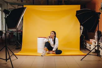 woman in white long sleeve shirt sitting on yellow floor tiles