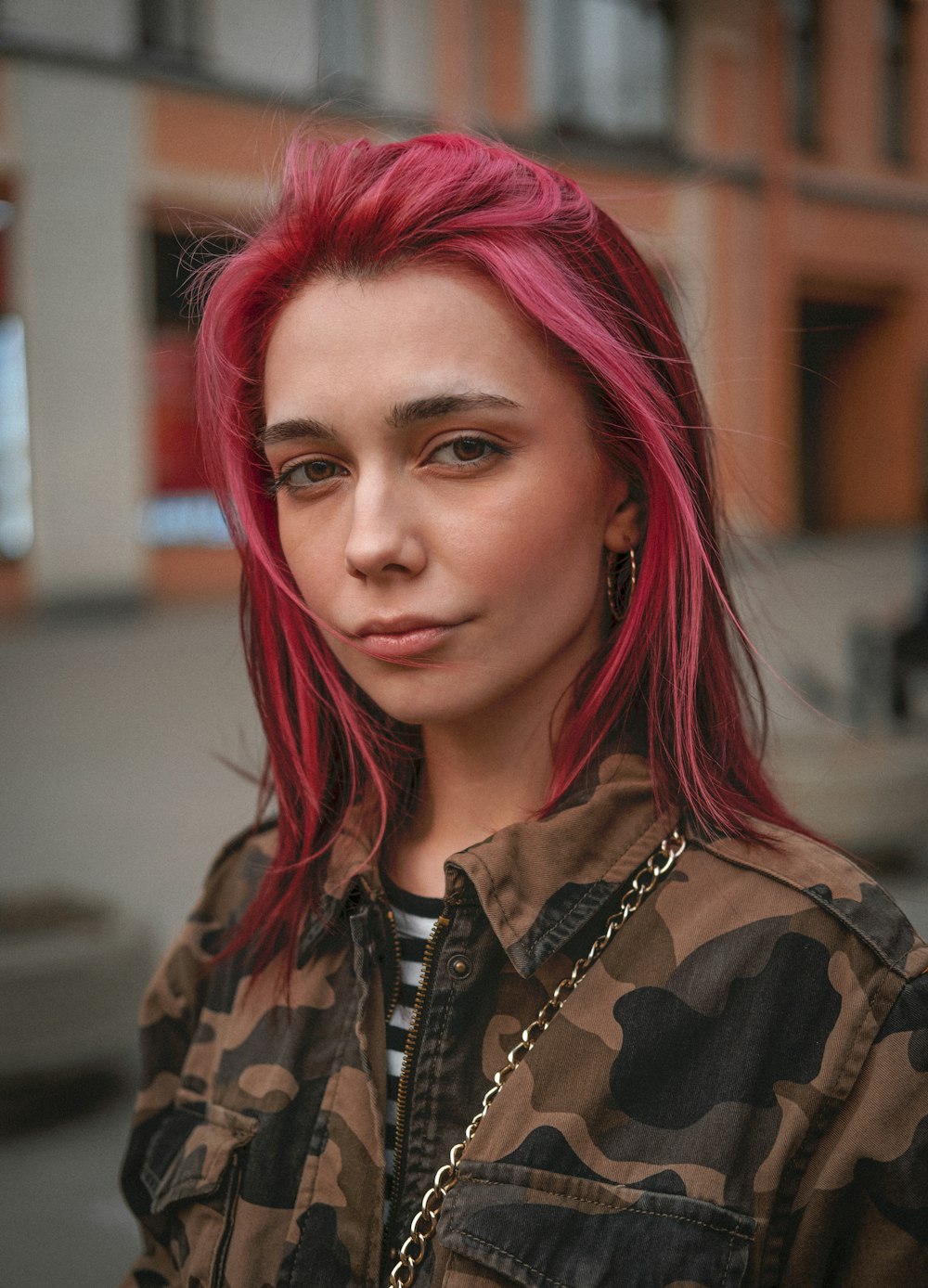 woman in black and brown camouflage shirt with pink hair