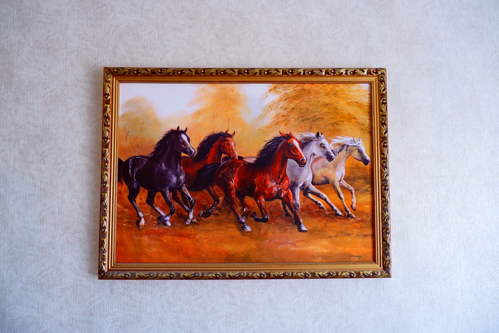 brown wooden framed painting of horses