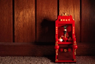 A softly glowing LDS temple replica displayed on a wooden shelf with family photos nearby.