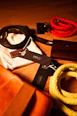 A display of men's fashion accessories including belts and hats in warm tones.