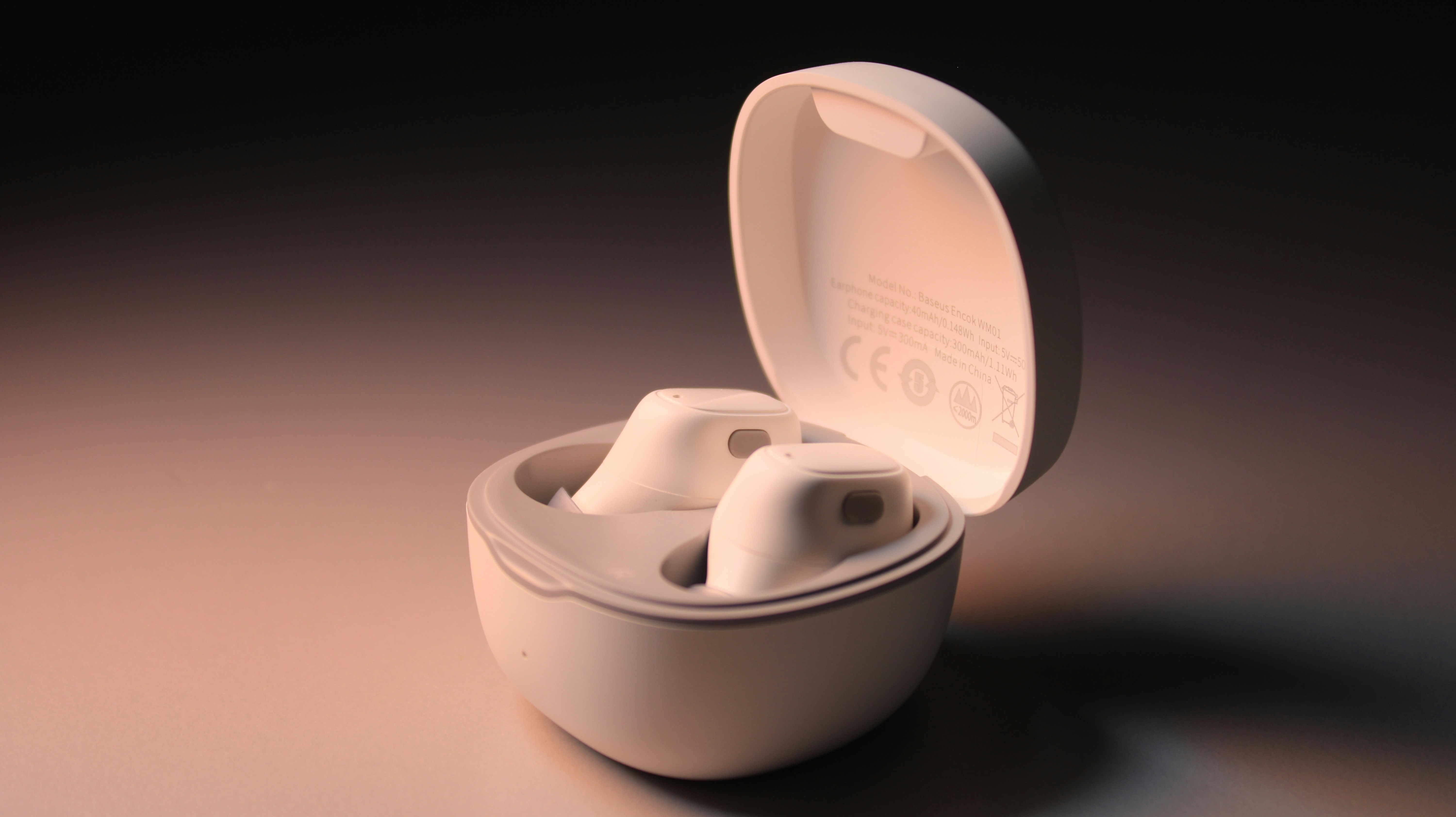 White wireless earbuds with charging case on gradient background
