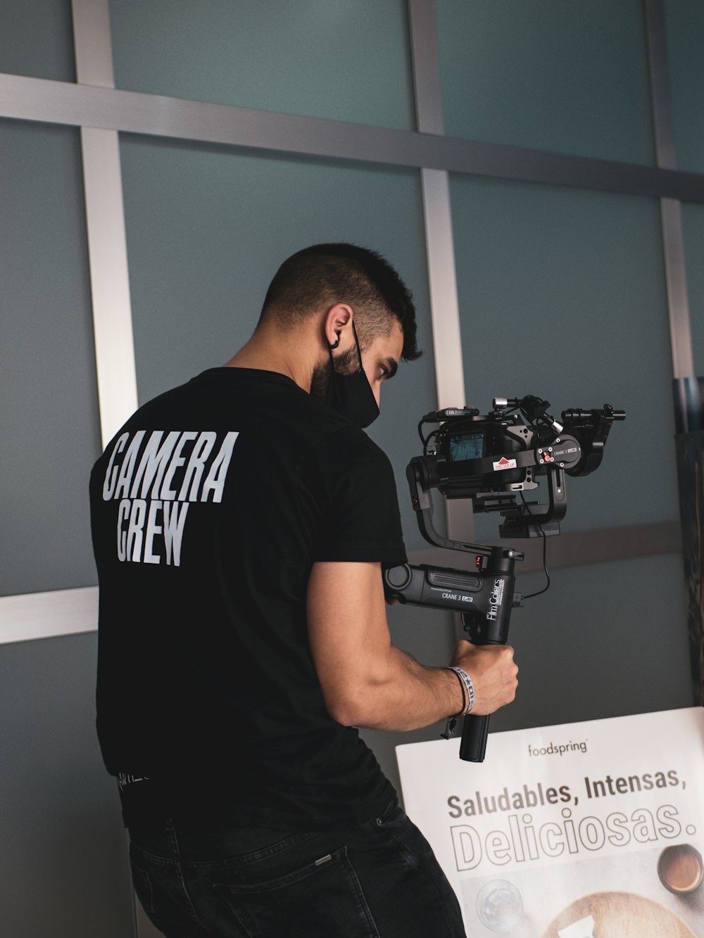 man in black crew neck t-shirt holding black camera