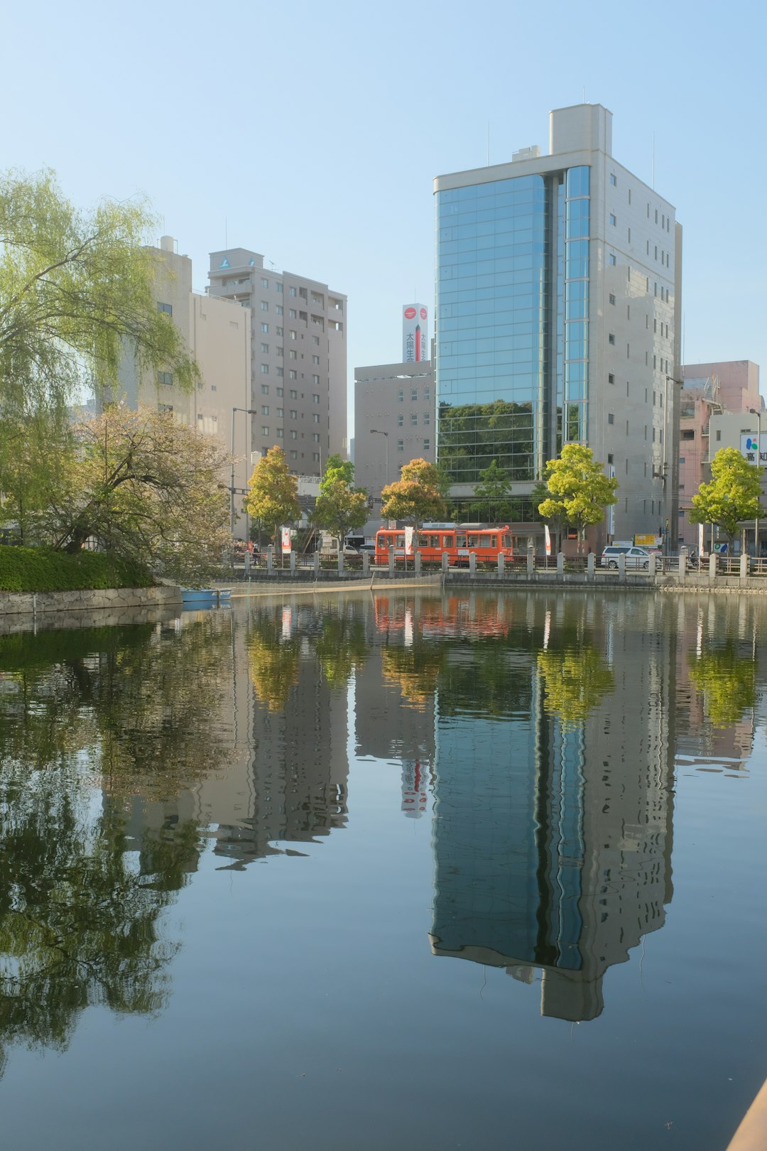 body of water near trees and high rise buildings during daytime