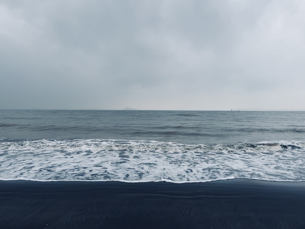 ocean waves under cloudy sky during daytime