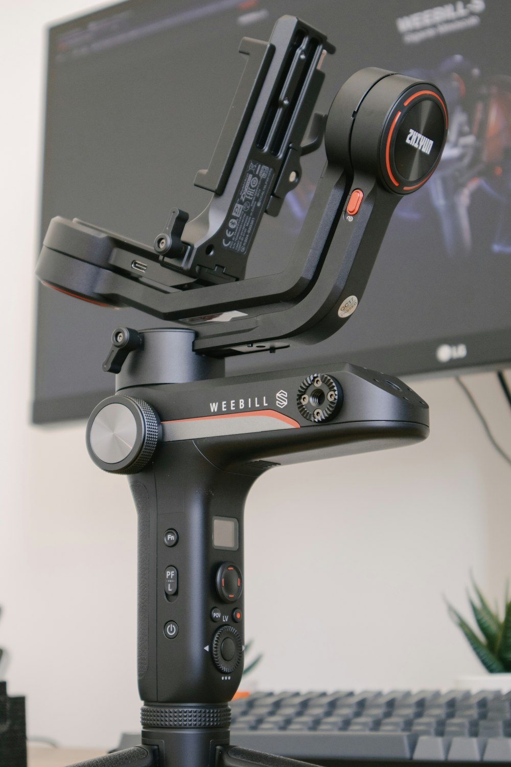 a camera sitting on top of a tripod next to a keyboard