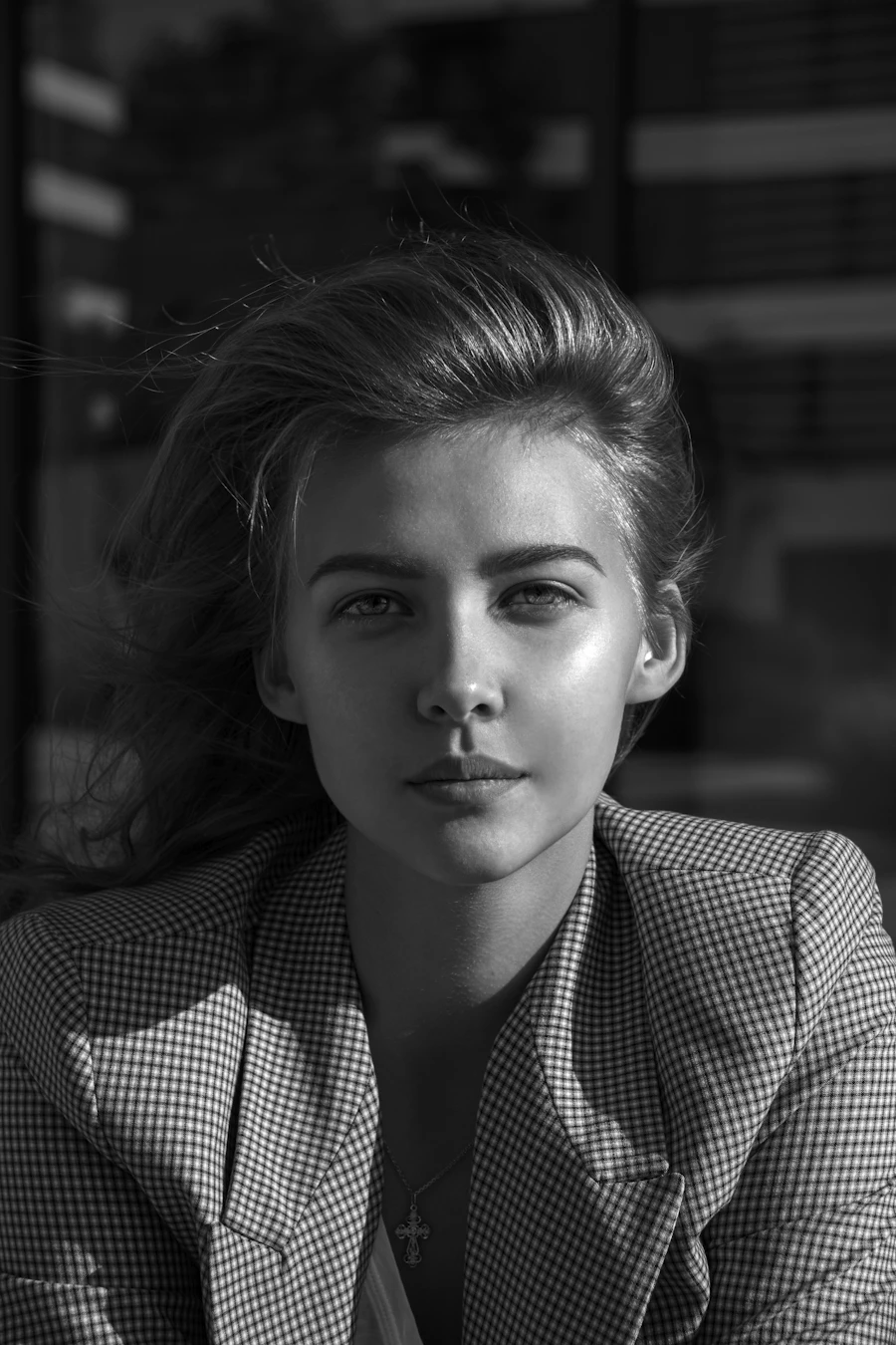 A black and white portrait of a young woman looking straight at the camera